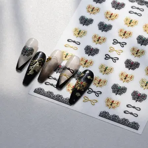 Detail van M-915 nagelstickers met zwarte kantvlinders en gouden strikjes patronen