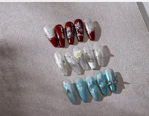 Detailed close-up of coffin press-on nails with 3D camellias, pearls and glitter finish