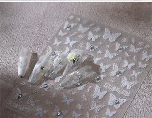 Detailed view of 3D butterfly nail stickers with lace patterns and white floral accents