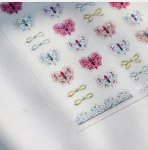 Macro detail of 3D embossed nail stickers featuring colorful bows and lace patterns