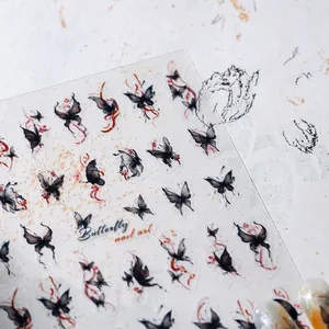 Detailed view of ink butterfly nail stickers with black and red delicate artistic patterns