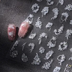 White lace flower and butterfly nail stickers with pearl 3D effect on pink nails