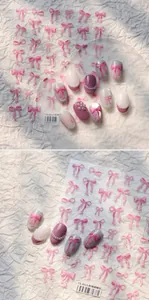 Dettaglio adesivi 5D per unghie con fiocco rosa su manicure perlata e glitterata