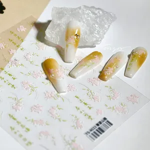 Macro detail of 3D floral nail art stickers with Chinese calligraphy and pearl accents