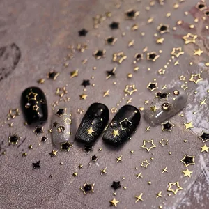 Macro detail of metallic gold and black star nail art stickers on dark glitter nails