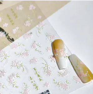 Macro detail of floral nail stickers with pink flowers, green leaves and Chinese script