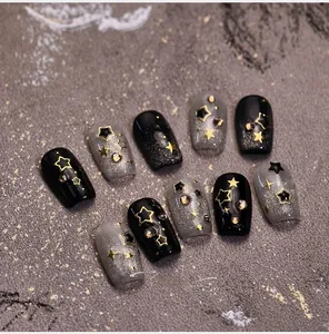 Detailed macro shot of dark luxury star nail art with cat-eye glitter and gold accents