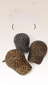 Close-up of three distressed leopard print baseball caps showing frayed edges and texture