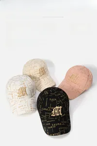 Detailed view of breathable fabric and 3D gold embroidery on stylish baseball caps