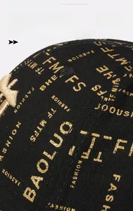 Close-up of black baseball cap featuring golden BAOLUO text and 3D star embroidery