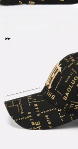 Detail of a black baseball cap with golden embroidery and 8cm long sunshade brim