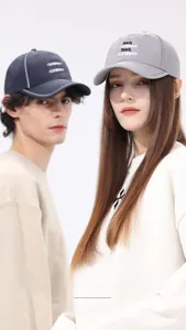Detail showing grey and navy quick-dry baseball caps with TRAVEL CALIFORNIAN embroidery