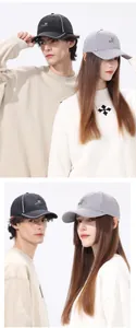 Detail view of quick-dry baseball caps in black and grey with sports logo and white piping