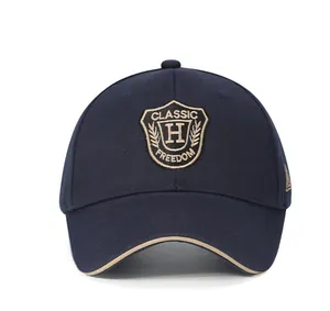 Close-up of golden shield embroidery and H letter logo on navy cotton baseball cap