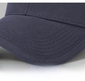 Detailed close-up showing reinforced stitching on the brim of the navy cotton baseball cap