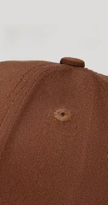 Macro detail of breathable embroidered eyelets on durable brown cotton baseball cap