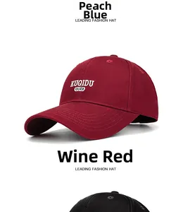 Close-up of wine red baseball cap featuring white letter embroidery and stitching
