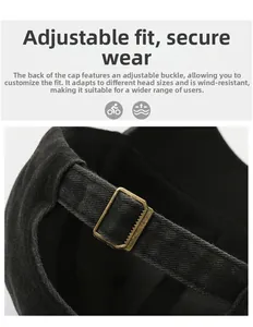 Detail of adjustable gold metal buckle on a black washed cotton baseball cap