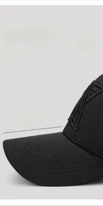 Detail of 7.5cm extended brim on black baseball cap showing premium woven fabric texture