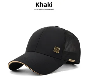 Close-up of black mesh baseball cap with gold metal badge and khaki brim piping detail