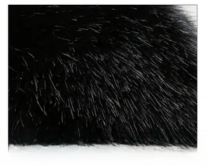 Close-up of premium black faux fur fabric showing dense and smooth texture on a winter hat