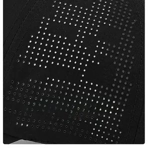 Detail view of quick-dry fabric with laser-perforated holes on a black baseball cap