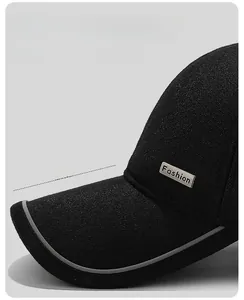 Detail der schwarzen Winter-Basecap mit 7,5 cm verlängertem Schirm und Metallemblem