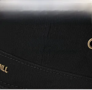 Close-up of black flat top cap detail featuring golden BILL lettering and breathable fabric