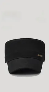 Detail of black cotton twill flat top hat with golden JUNGLEBILL metal side logo