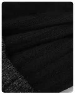 Close-up of black knit beanie fabric showing detailed soft wool texture and warm ribbing