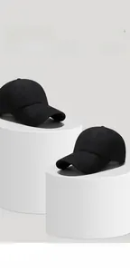 Detail view of two black baseball caps on white display stands featuring six-panel structure