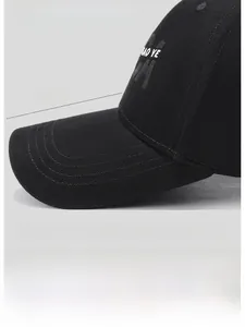 Detail showing the 8cm extended brim and structured crown of the black baseball cap