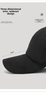 Detail view of the 8cm wide curved brim on a thick black wool baseball cap for men