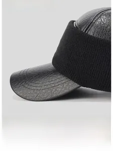 Detailed view of black faux leather baseball cap with knit ear flaps and wide brim