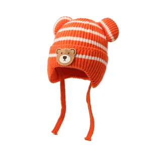 Warm orange striped knitted baby hat with bear ears and earflaps for winter