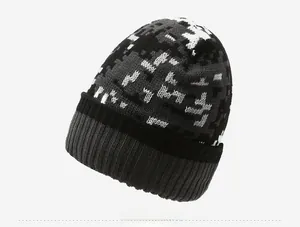 Detail view of winter knitted beanie featuring a grey pixelated camo pattern design