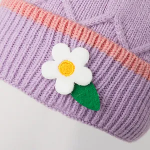 Lavendelgebreide babymuts met roze strepen en decoratieve witte bloemapplicatie
