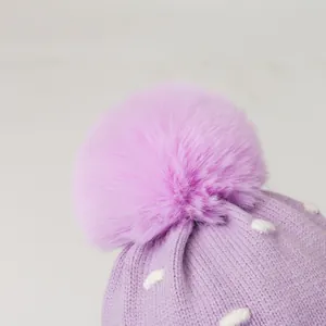 Schattige paarse wintermuts voor meisjes met witte stippen en een zachte kunstbont pompon