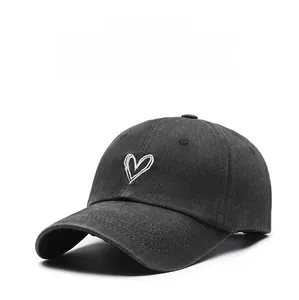 Close-up of vintage washed grey baseball cap with white heart embroidery and curved brim