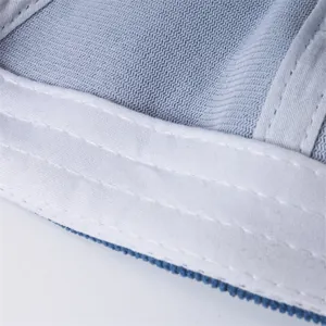 Detailansicht von atmungsaktivem blauem Netzstoff und Dreifachnähten an einer Kindermütze