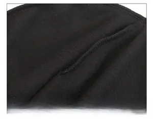 Gros plan sur la couture renforcée au sommet du bonnet d'hiver en polaire noire