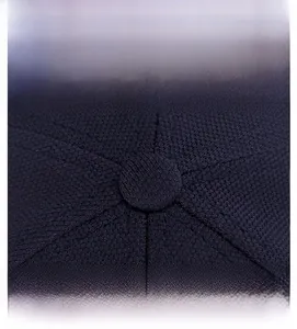 Close-up of the reinforced top button and fine stitching on a navy baseball cap