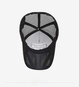 Detail view of the breathable mesh back and inner embroidery of the black trucker hat