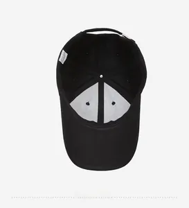 Detail showing inner stitching, white reinforcement, and care label of a black baseball cap