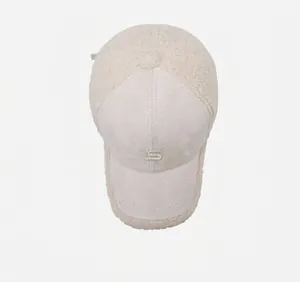 Top view of beige baseball cap with suede brim, teddy fleece panels and S embroidery