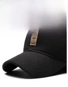Detail of a structured black winter baseball cap brim with a mountain logo leather patch