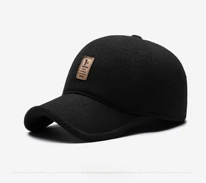 Detail of black winter baseball cap featuring textured wool fabric and brown leather logo patch