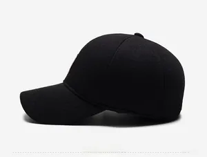 Side view of black winter baseball cap showing detail of brown leather logo patch