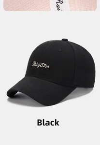 Detail of golden embroidered Riayant lettering on black cotton twill baseball cap