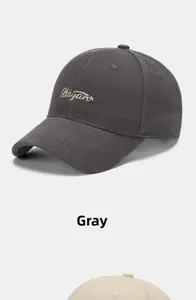 Detail of embroidered gold Rayant logo on grey and cream twill cotton baseball caps